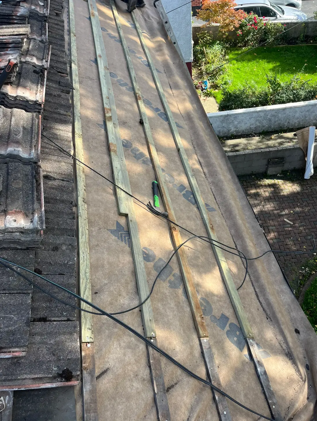 Roof underlay and timber battens installed beside existing roof tiles